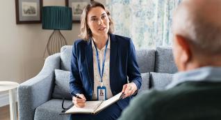 Fachkraft macht Notizen im Gespräch auf dem Sofa, Weiterbildung Empirische Sozialforschung